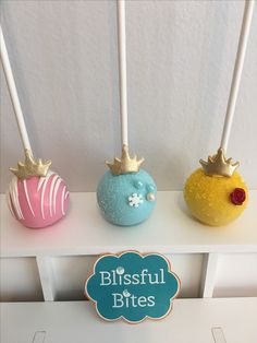 three cake pops are decorated with gold crowns