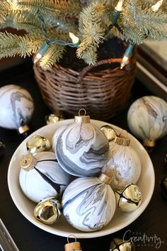 a white plate topped with ornaments next to a christmas tree