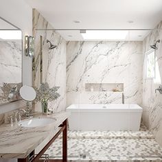 a bathroom with marble walls and flooring next to a bathtub under a window