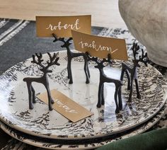 two place cards are placed on antlers on a plate