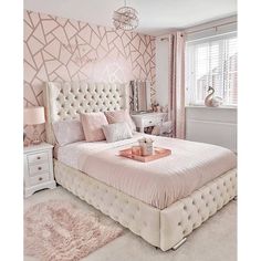 a white bed sitting in a bedroom next to a dresser and mirror on top of a wall