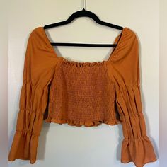 First Picture Is Actual Color, Burnt Orange. The Center Is Very Stretchy. Sleeve Are Puffy, And It Flairs Out At The Wrists. There Are Elastics In The Sleeves To Help It Puff Out. Size Small. Cropped. Never Worn Before - Great Condition! Orange Long Sleeve Shirt, Orange Country, Orange Top, Country Shirts, Crop Shirt, Burnt Orange, Colorful Shirts, Long Sleeve Shirts, Crop Tops