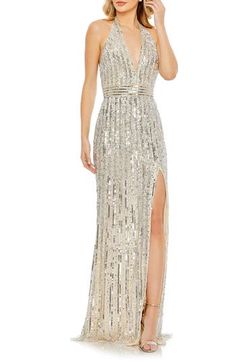 A gilded stunner of a gown is striped with sequins and perfectly paired with a golden glass of something sparkling. Plunge halter neck Sleeveless, with cutaway shoulders Lined 100% polyester Spot clean Imported Asian Owned/Founded Sequined Gown, Silver Sequin Dress, Sequin Halter, Sheath Gown, Trumpet Gown, Embellished Gown, Halter Strap, Mac Duggal, Silver Sequin