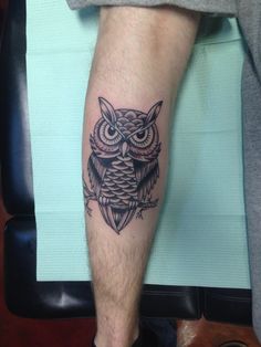 an owl tattoo on the leg of a man