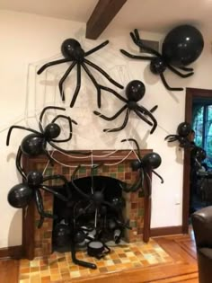 some black balloons are hanging from the ceiling in front of a fire place and fireplace