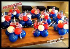 patriotic balloons and american flags are on display at the table for this fourth of july party