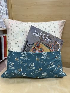 a pillow with a book in it on a table next to some bookshelves