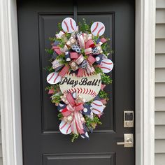 a baseball wreath with the words play ball on it is hanging on a front door