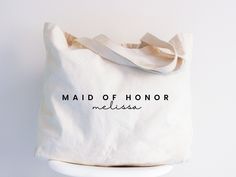 a white tote bag that says maid of honor mellisa on it