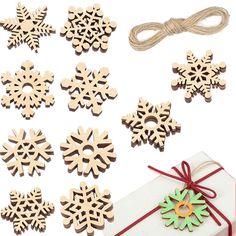 wooden snowflake ornaments and string tied to a white present box with red ribbon