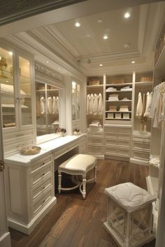 a walk in closet with white cabinets and drawers