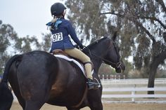 a woman riding on the back of a brown horse