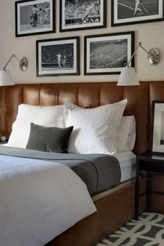 a bedroom with pictures on the wall above the bed and below the bed is a lamp