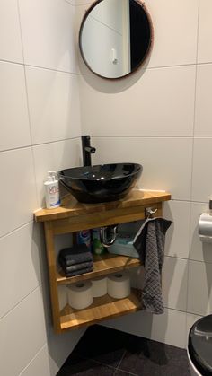 a bathroom with a sink, mirror and toiletries on the shelf next to it