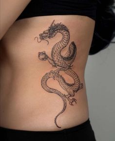 a woman's stomach with a dragon tattoo on her lower back and side view