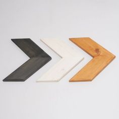 three different colored wooden arrows on a white background