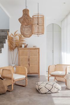 a living room with wicker furniture and large mirrors on the wall, including two chairs