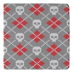 a gray and red knitted pattern with skulls on the front, one skull is in the middle