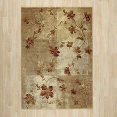 an area rug with flowers and leaves on the floor in front of a wooden wall