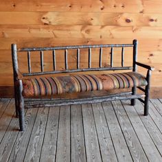 a wooden bench sitting on top of a wooden floor next to a wood paneled wall