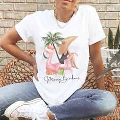 a woman sitting on a wicker chair wearing a t - shirt with a flamingo design