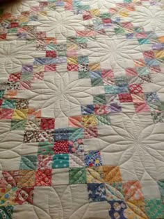 a quilt is laying on top of a bed