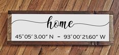 a sign that says home on it sitting on top of a wooden floor next to a wall