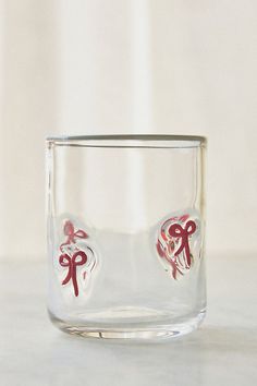 a clear glass with two hearts and bows on the inside is sitting on a table