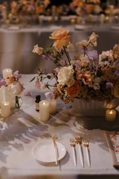 the table is set with flowers and candles