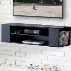 a flat screen tv mounted to the side of a wall next to a book shelf