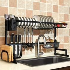 a kitchen sink and dish rack with utensils hanging from it's sides