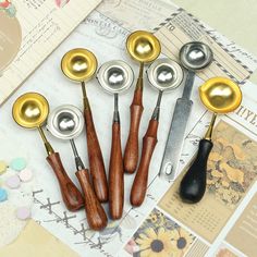 six wooden spoons are lined up next to each other with metal caps on them