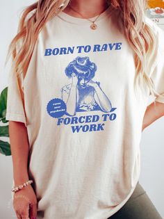 Tee with retro man design here ➡️: https://www.etsy.com/listing/1844202641/born-to-rave-forced-to-work-shirt-unisex? Express your inner rave lover with this playful "Born to Rave, Forced to Work" shirt. Featuring a vintage-style illustration of a woman looking frustrated and a quirky slogan, this tee is perfect for anyone who lives for raves and festivals but has to deal with the daily grind. The retro blue print on a cream-colored shirt adds a unique touch, combining humor and style with a subt Rave Style Cotton T-shirt With Crew Neck, Cotton Crew Neck T-shirt For Rave, Rave Cotton Crew Neck Tops, Cotton Rave Crew Neck Top, Cotton Rave Top With Crew Neck, Cotton Crew Neck Rave Tops, Cotton Graphic Print Rave Tops, Rave Cotton Top With Letter Print, Rave Cotton Tops With Letter Print