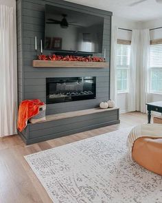 a living room with a couch, chair and fireplace in the middle of the room