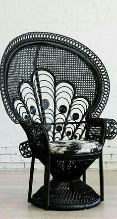 a black peacock chair sitting on top of a hard wood floor