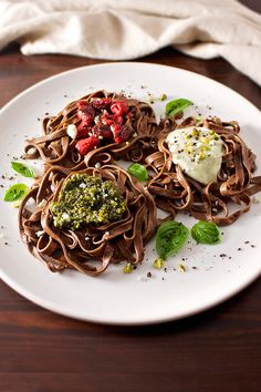 some food is on a white plate with brown noodles and broccoli florets