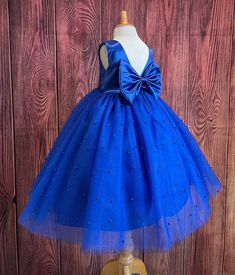 Our enchanting Ankle Length flower girl dresses are sure to turn heads! Bodice is made of Royal Blue Satin, waist consists of a matching sowed in sash (NOT DETACHABLE) The back of the dress has an open deep V-Back with a hidden zipper, followed by a detachable bow. The skirt has 4 tulle layers for fullness, the top layer of tulle consists of pearls. The dress has 2 layers of lining with crinoline. This dress is perfect for any occasion!  Dress Is Pictured with a petticoat NOT INCLUDED https://www.etsy.com/listing/1305138635/white-ankle-length-petticoat-wedding?click_key=50d449c187c9e82c565249da914d7ed38b32b9f7%3A1305138635&click_sum=17db9314&ref=shop_home_active_2 Visit our store, more items to come!  https://www.etsy.com/shop/LittledarlnBoutique?ref=profile_header CUSTOM MEASUREMENTS AVAI Fitted Royal Blue Princess Dress For Pageant, Royal Blue Fitted Princess Dress For Pageant, Royal Blue Flower Girl Dress, Blue Pageant Dress For Spring Wedding, Blue Sleeveless Ball Gown For Pageant, Sleeveless Blue Ball Gown For Pageant, Spring Wedding Blue Pageant Dress, Blue Princess Dress For Prom Season, Princess Style Blue Ball Gown For Bridesmaid