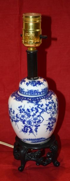 a blue and white vase sitting on top of a wooden stand next to a red wall