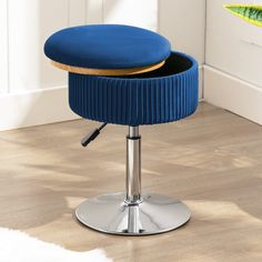 a blue stool with a wooden seat and metal base in front of a white wall