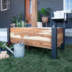 a wooden planter sitting in the grass next to a house