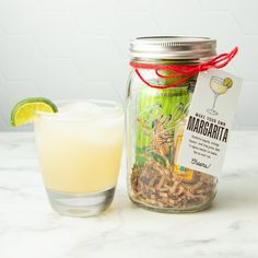 a glass filled with liquid sitting next to a jar full of food and a drink