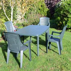 an outdoor table and chairs in the grass