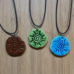 three necklaces with different designs on them