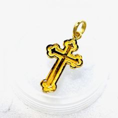 a gold colored cross pendant on a white background with space for the word jesus written below it