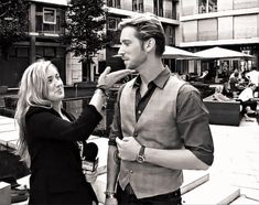 black and white photograph of a man getting his hair combed by a blonde woman