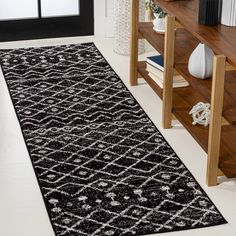 a black and white area rug on the floor in front of a book shelf with books