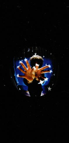 a person with their hands out in front of an american flag and stars on a black background