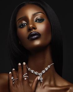 a woman with dark makeup and jewelry on her chest