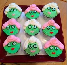 cupcakes with green and white frosting decorated to look like the faces of zombies