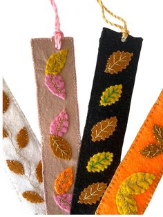 three decorative fall leaves are hanging from twine